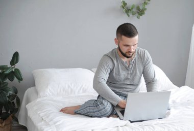 Dizüstü bilgisayarı olan adam evde çalışıyor..