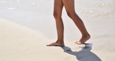 Kum dokusunda kadın bacakları.