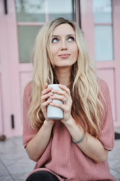 Beautiful woman with cup of hot drink outdoors. Autumn concept.