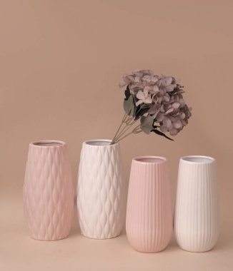 bej arkaplanda dekoratif vazoda suni çiçekler