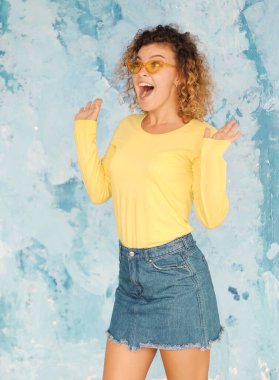 Güzel kıvırcık saçlı kadın arka planda poz veriyor.. 