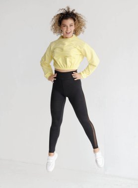 Açık arkaplanda güzel kıvırcık saçlı dansçı. 