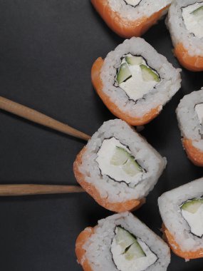 Japonlar yiyecekleri koyu arkaplanda yuvarlar.