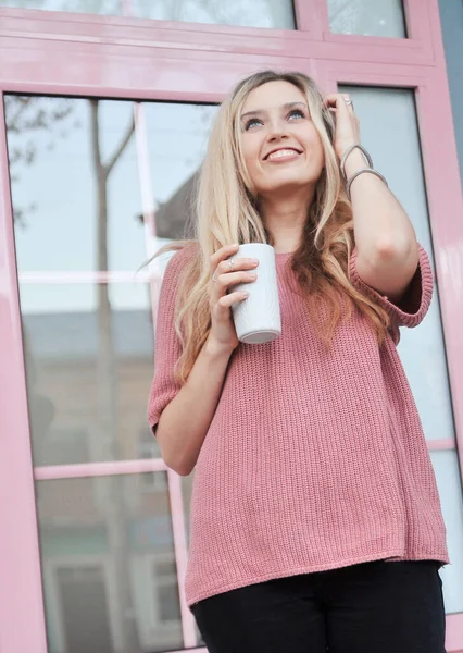 Açık havada bir fincan sıcak içeceği olan güzel bir kadın. Sonbahar konsepti.