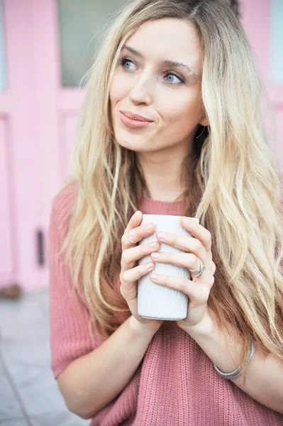 Açık havada bir fincan sıcak içeceği olan güzel bir kadın. Sonbahar konsepti.