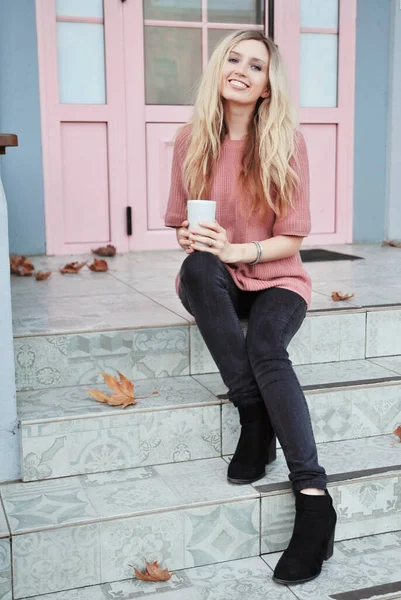 Açık havada bir fincan sıcak içeceği olan güzel bir kadın. Sonbahar konsepti.