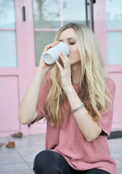 Açık havada bir fincan sıcak içeceği olan güzel bir kadın. Sonbahar konsepti.