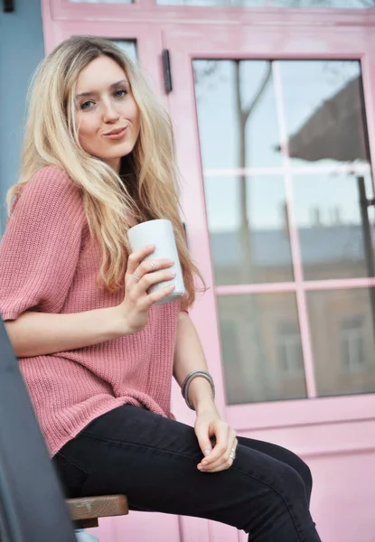 Açık havada bir fincan sıcak içeceği olan güzel bir kadın. Sonbahar konsepti.