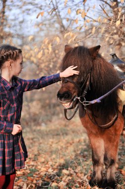 Küçük kız ormanda atla oynuyor..