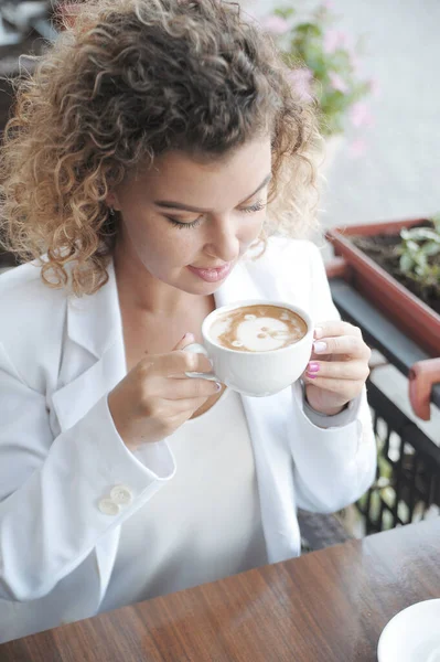 아름다운 여성이 카페에서 커피를 마십니다 바깥에 랩탑을 가지고 — 스톡 사진