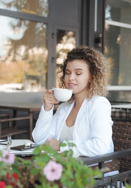 아름다운 여성이 카페에서 커피를 마십니다 바깥에 랩탑을 가지고 — 스톡 사진