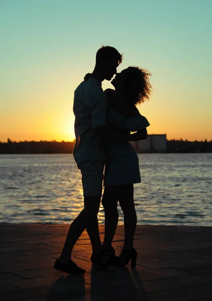 日落时在海滩上亲吻的快乐夫妻 — 图库照片
