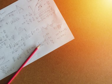 Masanın üzerindeki bir kağıt üzerindeki matematiksel denklemler, ışık etkisi