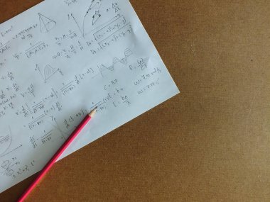 Masadaki bir kağıt üzerindeki matematiksel denklemler