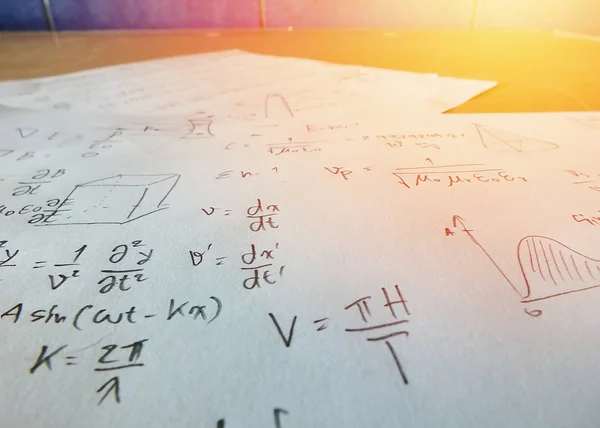 Close up mathematical equations on a sheet of paper , light effect
