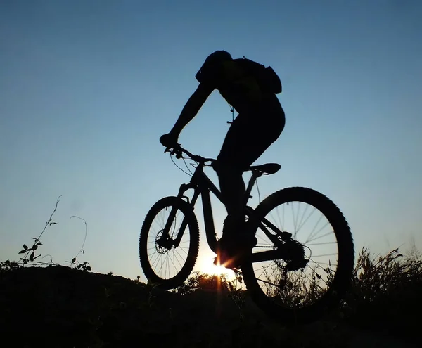 Mountain bike racing silhouette in sunrise