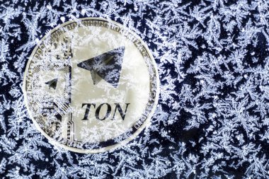 Cryptocurrency TON from telegram. Silver coin ton is covered with ice. clipart