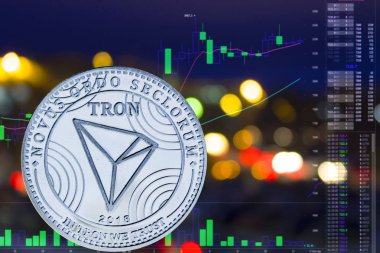 Sikke cryptocurrency Tron gece şehir arka plan ve grafik.