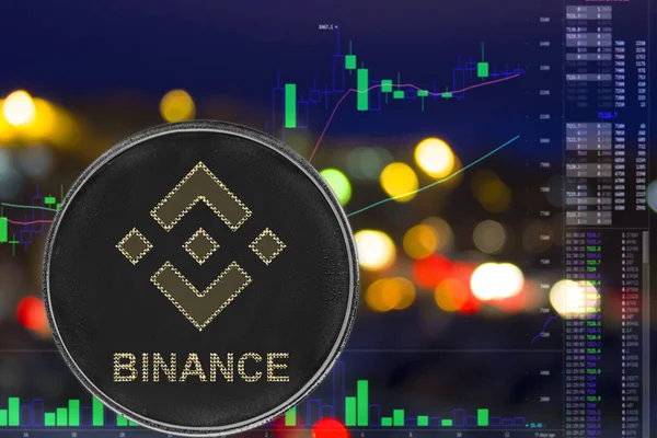 Gece şehir arka plan ve grafik üzerinde sikke cryptocurrency binance.