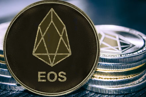 Маркер криптовалюту EOS на фоні стосу монет. — стокове фото