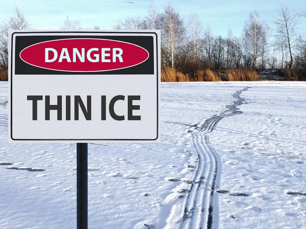 Знак небезпеки тонкий лід і відбитки ніг дорога на снігу і льоду Стокова Картинка