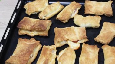 Jambon ve peynir ile sıcak puflar. Masadan çıkarılan puflarla pişirme tepsisi