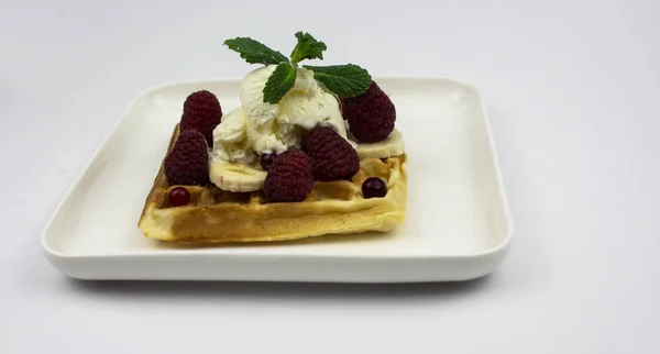 Waffle con helado, frambuesas y plátanos en un plato blanco . — Foto de Stock