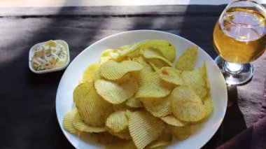 patates cipsi ve koyu bir arka plan üzerinde içki. Güneş ışınları masaya yansır. kafe veya restoran