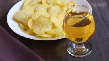 patates cipsi ve koyu bir arka plan üzerinde içki. Güneş ışınları masaya yansır. kafe veya restoran
