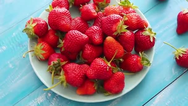 新鲜的草莓草莓背景 宏纹理 大草莓 在蓝色背景上 草莓在桌子上旋转 — 图库视频影像
