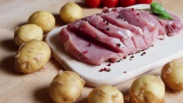 Filetes Cerdo Una Tabla Madera Patatas Nuevas Tomates Cherry Verduras — Vídeos de Stock