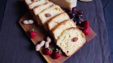 Çilek, fıstık ve badem ile koyu bir arka plan üzerinde ev yapımı kek pişirme. Pasta parçalara ayrılır. Yukarıdan görüntüle