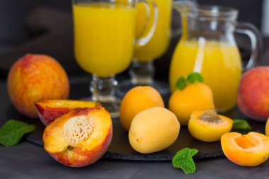  Yaz kayısı suyu. Taze şeftali suyu. Koyu yeşil yapraklı şeftali ve kayısılar. kopyalama alanı