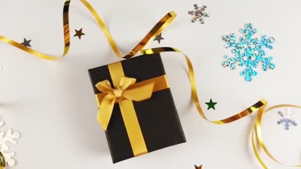 ホリデークリスマスの背景 ゴールドリボン新年とクリスマスとブラウンボックス クリスマスの背景に贈り物 雪片だ 上からの眺め — ストック動画
