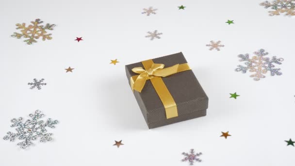 白い背景に金のリボンとギフト クリスマスカードの背景 雪の結晶と贈り物 — ストック動画