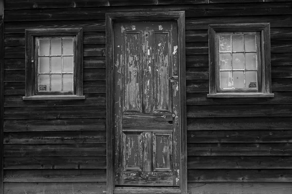 玄関のドアの塗料を剥離 黒と白の素朴な建物 — ストック写真