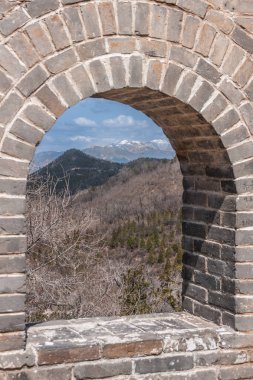 Beijing, Çin - 28 Nisan 2010: Çin Seddi Badaling adlı. Gri-yeşil vahşi ve Dağları kar üstleri ile mavi gökyüzü altında ufukta duvar penceresinde gösterir.