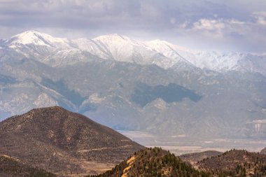 Beijing, Çin - 28 Nisan 2010: Çin Seddi Badaling adlı. karlı üstleri ve ışık mavi bulutlu gökyüzü ile duvar geçmiş uzun boylu dağ aralığının geniş atış. Orman önünde.