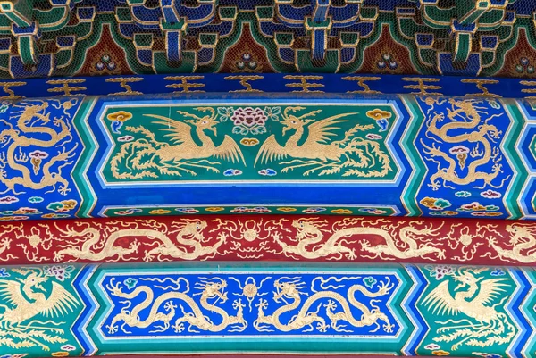 Beijing, China - April 29, 2010: Temple of Heaven park. Closeup of beam decorations show golden dragons on full blues, green and red.