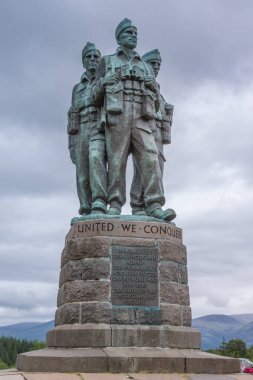Lochander, İskoçya - 11 Haziran 2012: Closeup yeşil-gri bronz komando anıt heykel A82 boyunca ve Spean Nehri yakınında bulutlu gökyüzü altında. Ufuk tepelerinde.