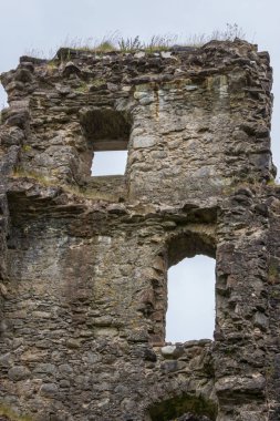 Invergarry, İskoçya - 11 Haziran 2012: Closeup uzun boylu, koyu kahverengi yıkık Duvar ile pencere açıklıklar kale Invergarry, gri gökyüzü altında.