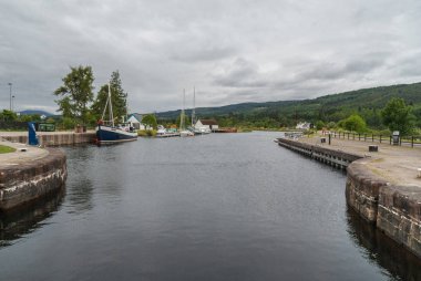 Fort Augustus, İskoçya - 11 Haziran 2012: Oich kanal kilitleri arkasında. Ağır gri gökyüzü altında ufukta zevk tekneler demirli, yeşil hils Dock tarafında vardır.