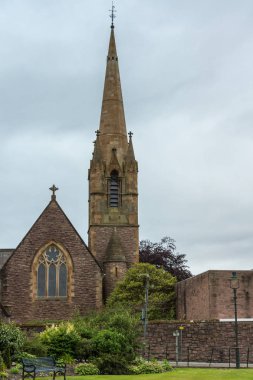 Fort William, İskoçya - 11 Haziran 2012: Parade, Saint Andrews churdh arka plan olarak ışık mavi gökyüzü ile. Yeşil park ön.