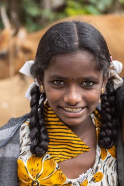 Belathur, Karnataka, Hindistan - 1 Kasım 2013:, kız teklif veda töreni sırasında pilgirms çıkış için gülümseyen bir portre. Uzun siyah saçları kulak takı. Beyaz sarı ve siyah sari.