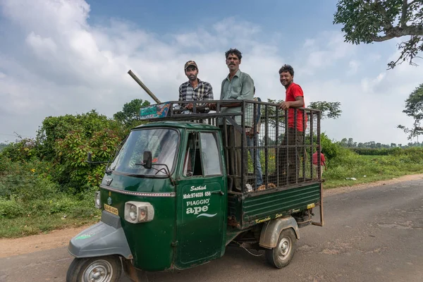 Belathur カルナタカ インド 2013 ダーク グリーン三輪車車は つの農場労働者 積載エリア フィールドに車の上に立っている男性を笑顔をもたらします 青い空と白い雲と道路シーン — ストック写真