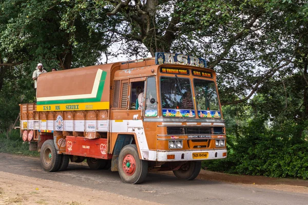 印度卡纳 Belathur 2013年11月1日 橙色卡车装载了水钻井设备沿路在绿色船盖之下 司机和男子在后面可见 — 图库照片