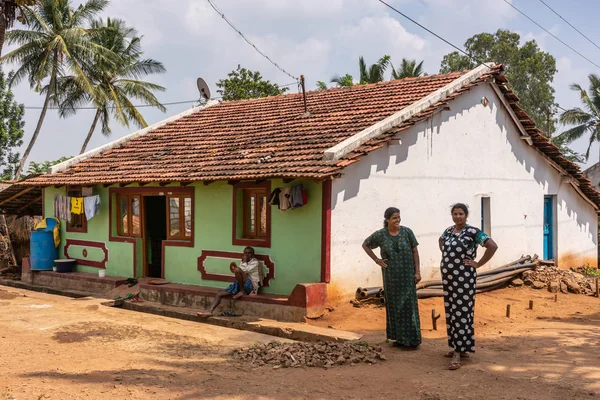 Nilavagilukaval 卡纳卡 2013年11月1日 两个微笑的女人和一个男人在他们的一个故事石头大厦与红色平底锅屋顶 棕色土路和露天下水道 — 图库照片