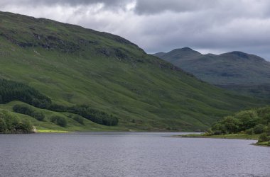 Bridge of Orchy, İskoçya, İngiltere - 12 Haziran 2012: Tulla mavimsi gri loch çevrili yeşil tepelerle, biraz koyu ormanlık, en çıplak yeşil altında ağır bir cennet. Su ön geliyor.