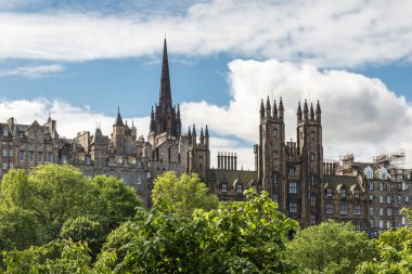Edinburgh, İskoçya, İngiltere - 13 Haziran 2012: Yeni College, University of Edinburgh Scott anıt beyaz bulutlar ile mavi gökyüzü altında yeşil park arasında görülen Pazar sokağında.