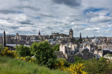 Edinburgh, İskoçya, İngiltere - 13 Haziran 2012: Calton Hill kalenin altında ağır cennet kasabaya üzerinden arıyorum. Ön sarı ve yeşil bitki örtüsü.
